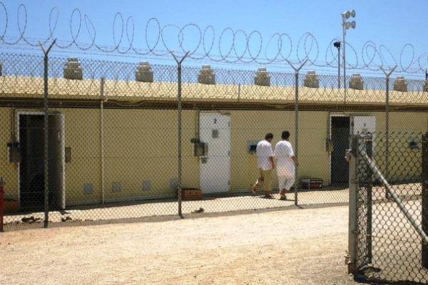 Detainees walk around an exercise yard in Camp 4, the medium-security facility within Camp Delta in 2006 at Naval Station Guantanamo Bay, Cuba. (Army photo by Sara Wood)