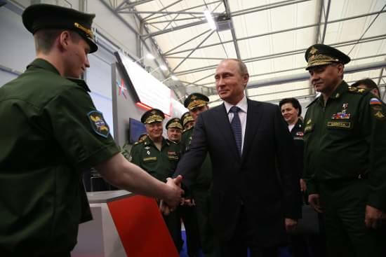 KUBINKA, RUSSIA - JUNE 16: Russian President Vladimir Putin (C) shakes hands with an officer as Defence Minister Sergei Shoigu (R) looks on during his visit to the International Military-Technical Forum ARMY-2015 at Patriot park June 16, 2015 n Kubinka, Russia. The forum is geared towards demonstrating capabilities of scientific organizations, defence industry businesses, weapons and equipment production, innovative technologies, both from Russia and abroad.  (Photo by Sasha Mordovets/Getty Images)