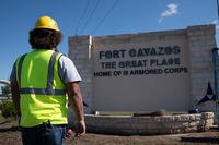 A government contractor in front of the Clear Creek access control point takes a step back to ensure the letters are aligned correctly in preparations for the redesignation of the former Fort Hood to Fort Cavazos in Texas.