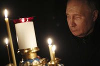 Russian President Vladimir Putin lights a candle