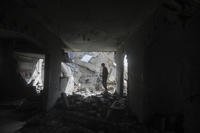 Palestinians look at the destruction after an Israeli strike in Rafah
