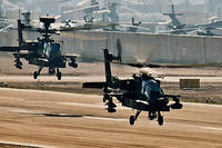 AH-64D Apache attack helicopters from Company C, 4th Battalion, 227th Aviation Regiment, 1st Air Cavalry Brigade, 1st Cavalry Division, depart from the flightline at Camp Taji, Iraq in 2009.
