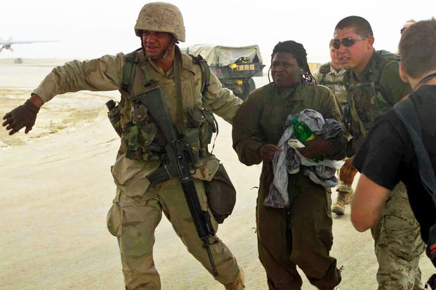 Spc. Shoshana Johnson, of the 507th Maintenance Battalion, is ushered to a waiting Marine Corps KC-130 aircraft a few miles south of Baghdad, for a flight to Kuwait City, April 13, 2003. (U.S. Marine Corps/Michael Leitenberger)