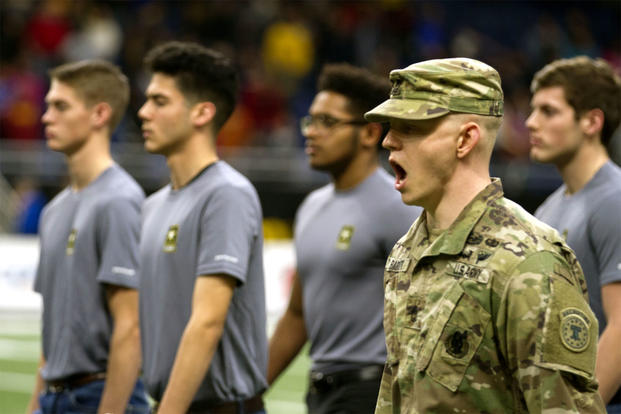 An Army soldier marches recruits onto the football field at the Alamodome in San Antonio, Texas, on Jan. 6. The Army has lowered its recruitment goal for this year to 76,500 new troops. (US Army photo/Ian Valley)