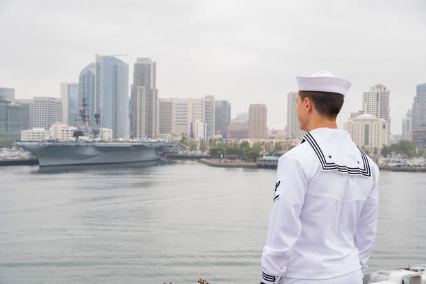 Operations Specialist 3rd Class Cody Wood looks on from the flight deck of the amphibious assault ship USS Bonhomme Richard (LHD 6) as the ship passes the USS Midway Museum during its arrival in San Diego, Calif., May 8, 2018. (U.S. Navy photo/Zachary DiPadova)
