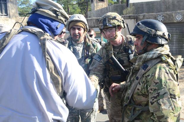 A combat advisor for the 2nd Battalion, 1st Security Forces Assistance Brigade shakes hands with a role player acting as an Afghan civilian to begin the process of settling the conflict in the simulated town of Batoor, Jan. 15, 2018, as part of rotation 18-03 at the Joint Readiness Training Center, at Fort Polk, La. (U.S. Army /Sgt. Ryan Tatum)