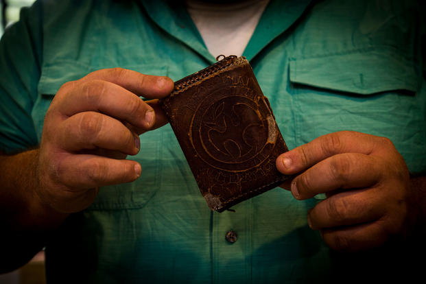Former Army Sgt. Tony Fantasia displays his first leatherwork project. He says working on the wallet saved his life. He now runs an outreach program for veterans focusing on various artistic outlets. (U.S. Air Force/Keifer Bowes)