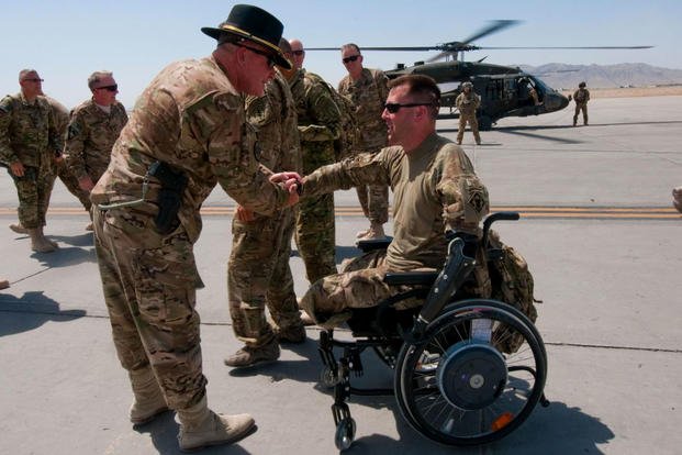 July 2014: Maj. Gen. Michael Bills greets retired Sgt. Adam Keys at Kandahar Airfield, Afghanistan. Keys served with the 20th Engineer Brigade before he was wounded in combat in 2010. He recently climbed Mt. Kilimanjaro and is preparing to run in the New York City Marathon Nov. 4. (US Army photo/Whitney C. Houston)