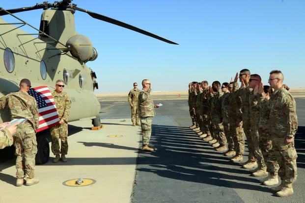 Soldiers from the 248th Aviation Support Battalion, Iowa Army National Guard, take the oath of re-enlistment at the Udairi Airfield, Camp Buehring, Kuwait, Feb. 4, 2018. (U.S. Army photo/Andrew Shipley)