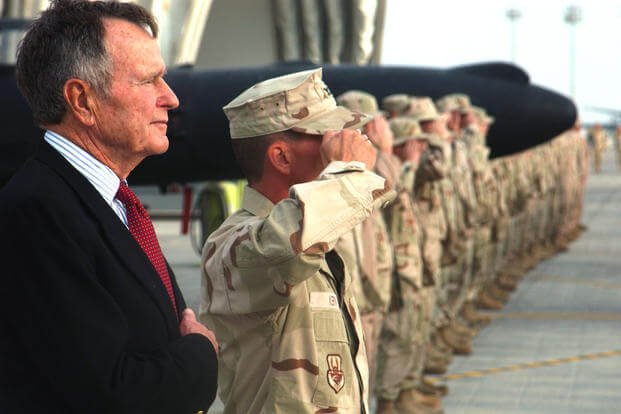 Former President George H.W. Bush listens to the national anthem with Airmen from the 380th Air Expeditionary Wing in 2006. (U.S. Air Force/Jason Tudor)