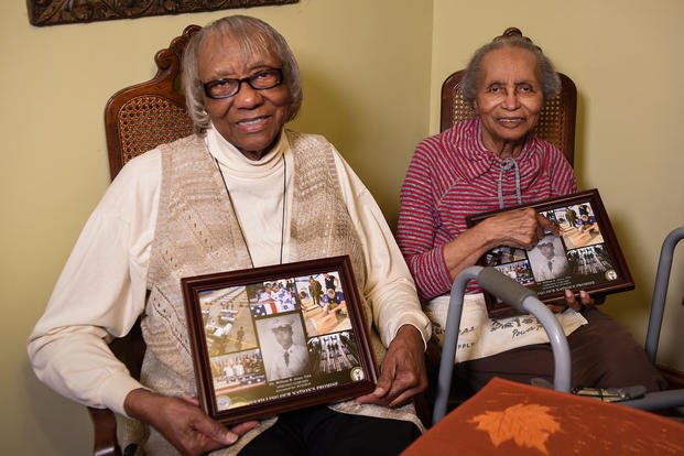 Ida Jones-Dickens, left, and Elizabeth Jones-Ohree hold collages presented to them by the Defense POW/MIA Accounting Agency (DPAA) at Elizabeth’s home in Rocky Mount, North Carolina, Nov. 15, 2018. (U.S. Air Force photo by Staff Sgt. Apryl Hall)