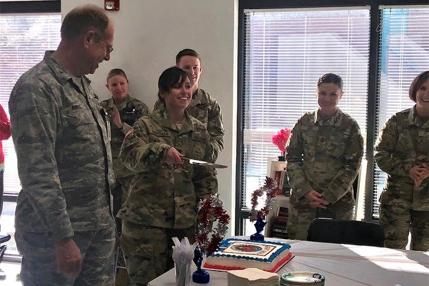 Spc. Ashley Hartman cuts the ceremonial birthday cake for the National Guard's 381st birthday alongside Nevada Adjutant General, Brig. Gen. William Burks, left. The Nevada National Guard Joint Forces Headquarters office celebrates the National Guard's birthday every year with the highest and most junior ranking members available as cake cutters. (Photo Credit: 2nd Lt. Emerson Marcus)