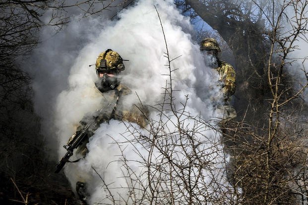Soldiers push through smoke from a grenade during the ground tactical movement portion of the Operation Bowie Strike training exercise in Zhegoc, Kosovo, Jan. 19, 2018. (U.S. Army photo by Staff Sgt. Nicholas Farina)