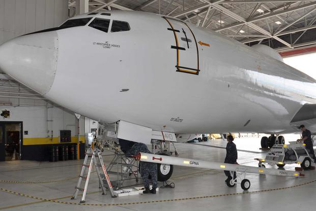 Sailors with the Navy’s VQ-4 Fleet Air Reconnaissance Squadron at Tinker Air Force Base, Oklahoma, make preparations for moving an E-6B Mercury out of a TACAMO hangar bay in 2013. (Air Force photo by Mike W. Ray)