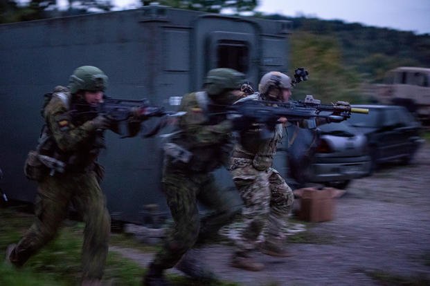 Members of the Lithuanian National Defence Volunteer Forces (KASP) and a U.S. Army Special Forces Soldier assigned to 20th Special Forces Group (Airborne) conducts a raid during exercise Saber Junction 2018 at the Joint Multinational Readiness Center in Hohenfels, Germany, September 22, 2018. (U.S. Army photo/Benjamin Haulenbeek)
