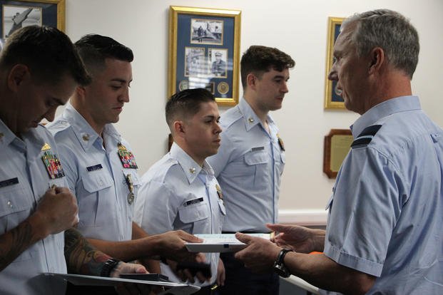 Air Commodore Paul Herber hands to Petty Officer Second Class George Soto the Humanitarian Service Medal recognition documents during the ceremony held at Air Station Miami Thursday Mar. 7, 2019. This medal was awarded to the U.S. Coast Guard Tactical Law Enforcement Team South in recognition of their relief efforts during Hurricane Irma in 2017. (Coast Guard photo/Erik Villa Rodriguez)