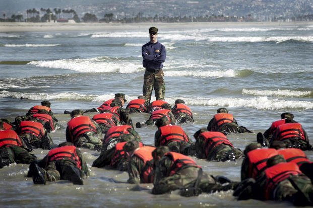 A Navy SEAL instructor watches BUD/S students.