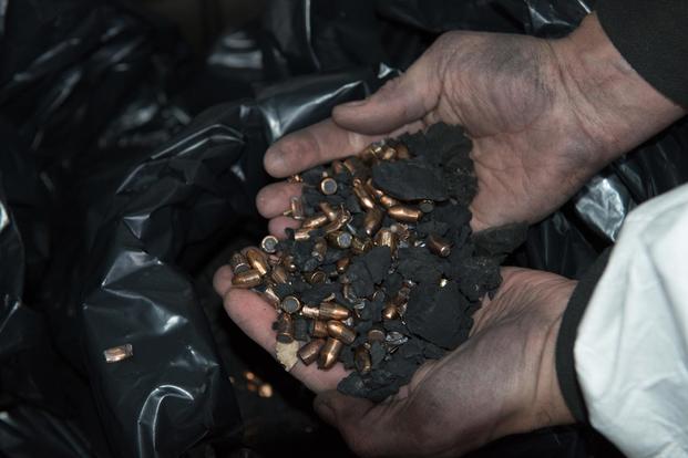 A contractor shows the bullets and rubber that he cleaned in the Training Support Center Benelux 25-meter indoor firing range, on Chièvres Air Base, Belgium, Dec. 6, 2017. (U.S. Army/Visual Information Specialist Pierre-Etienne Courtejoie)