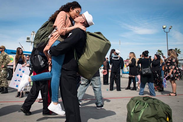 Damage Controlman 3rd Class Arturo Cunillasvaladez, from Big Bear Lake, Calif., assigned to Whidbey Island-class dock landing ship USS Rushmore (LSD 47), kisses his wife after returning to homeport. (U.S. Navy/Reymundo A. Villegas III)