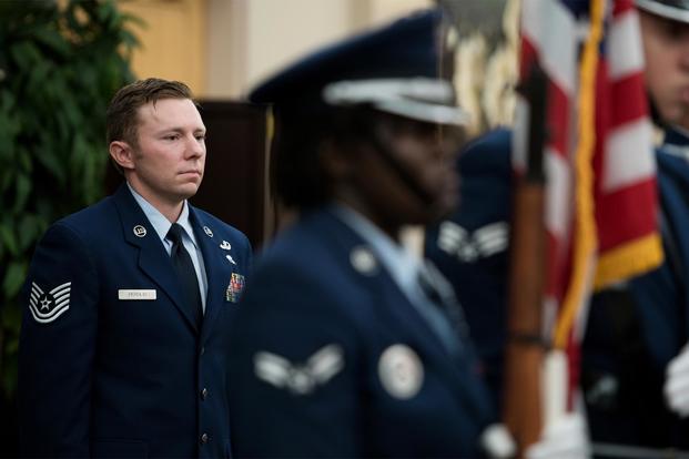 Technical Sgt. Michael Perolio, stands at attention during the playing of the National Anthem during an event in his honor, where he was presented both the Silver and Bronze Stars, at Joint Base San Antonio-Lackland July 18, 2019. (U.S. Air Force/Sarayuth Pinthong)