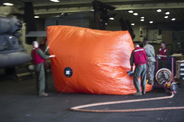 Marines prepare an inflatable target for an aerial gunnery and ordnance hot-reload exercise aboard the USS Wasp, Solomon Sea, August 4, 2019. (U.S. Marine Corps/Cpl. Cameron E. Parks)