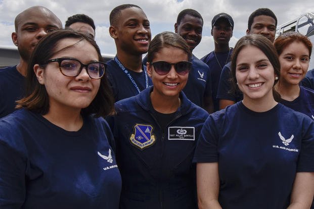Air Force Tech. Sgt. Nalani Quintello, U.S. Air Force Band vocalist for Max Impact, poses for a photo with Air Force recruits after their oath of enlistment. (U.S. Air Force/Michael S. Murphy)