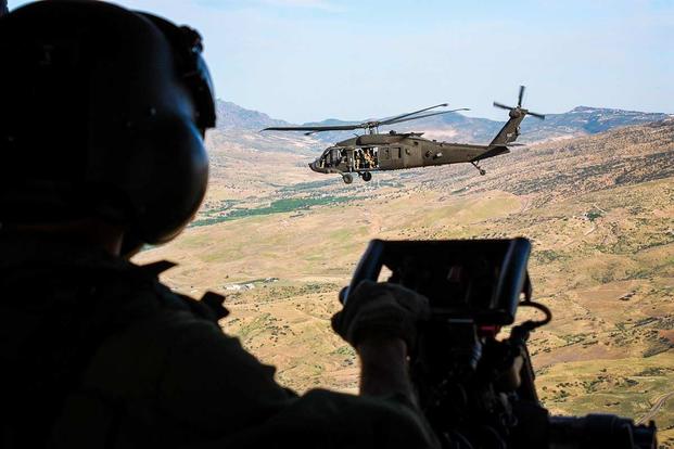 An Italian Army crewmember looks out an NH-90 helicopter as it flies alongside an American UH-60 helicopter during a multinational flight movement near Erbil, Iraq, on May 31, 2019. The helos’ primary missions are air movements and personnel recovery. (Photo by 1st Lt. Alison Carr/Task Force Griffon)