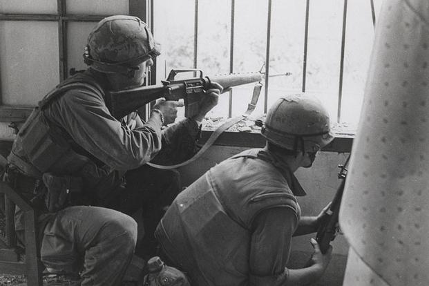 Marines A Company, 1st Battalion, 1st Marines [A/1/1] return fire from a house window during a search and clear mission in the battle of Hue, February 1968. (U.S. Marine Corps Archives & Special Collections/Sergeant Bruce A. Atwell)