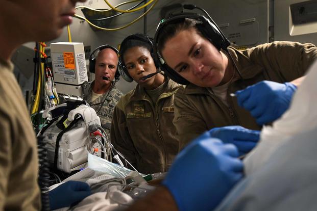 A critical care air transport team tends to a patient during a nearly 20-hour direct flight from Bagram Airfield, Afghanistan, to San Antonio on Aug. 18, 2019. The service member was cared for by a joint service team of extracorporeal membrane oxygenation specialists, an aeromedical evacuation team and a CCATT in order to maintain the highest level of care possible during transport. (U.S. Air Force photo by Airman 1st Class Ryan Mancuso)