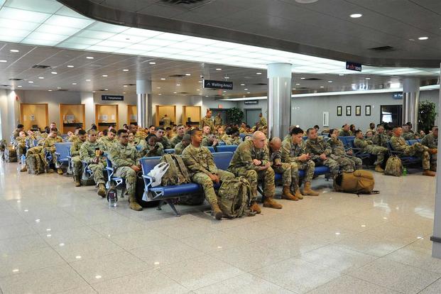 U.S. Soldiers wait to board a Korean Air Boeing 777 aircraft at Osan Air Base.