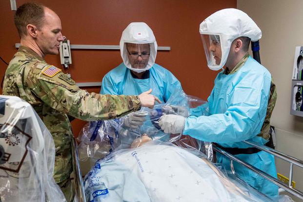 Lt. Col. Carl Skinner reviews procedures with doctors as they simulate care for a COVID-19 patient at Madigan Army Medical Center.