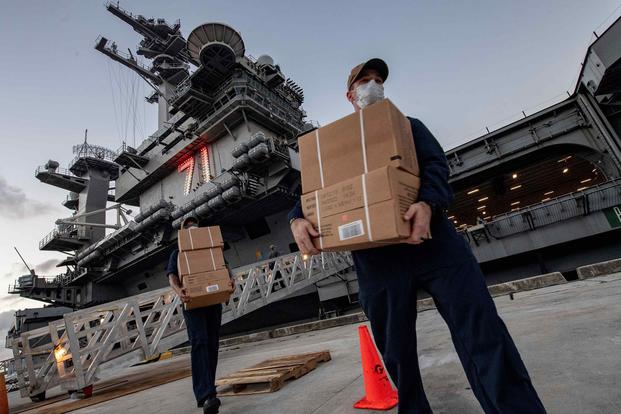 Sailors assigned to the USS Theodore Roosevelt move MREs for sailors who have tested negative for COVID-19 and are asymptomatic at local hotels.