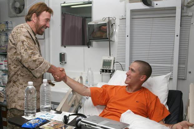 Actor Chuck Norris meets with a service member admitted to the Task Force 399th Combat Support Hospital aboard Al Asad Air Base, Iraq. 