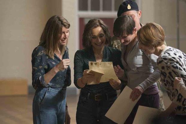 women gather around a letter