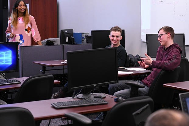 students sitting in classroom with computers