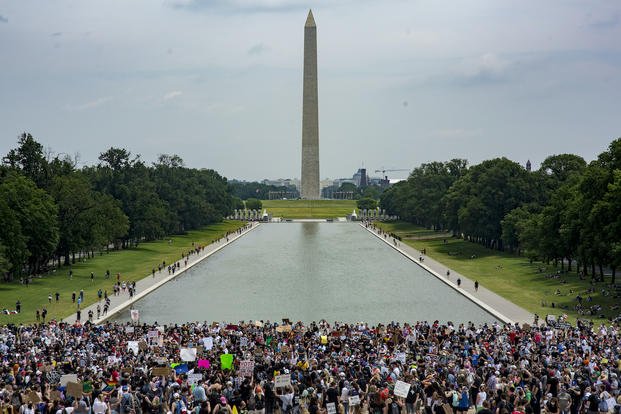 a large crowd gathered near the reflecting pool in DC