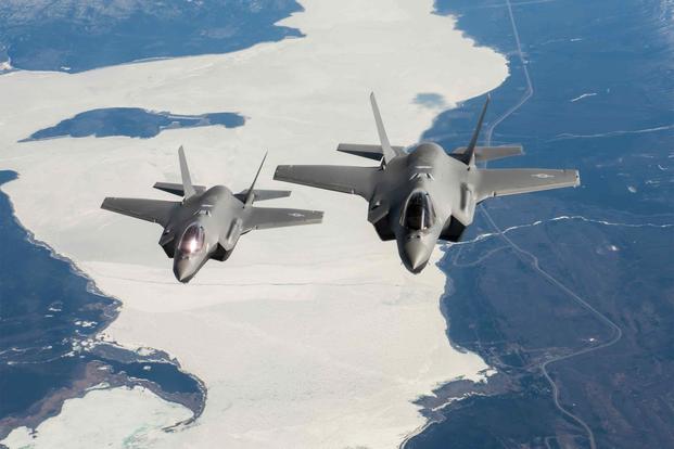 Two F-35A Lightning II fighter aircraft fly over the Alaska Canada Highway.