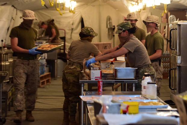 Airmen and Marines prepare food at the Sandstorm field kitchen, Ahmed Al Jaber Air Base, Kuwait.