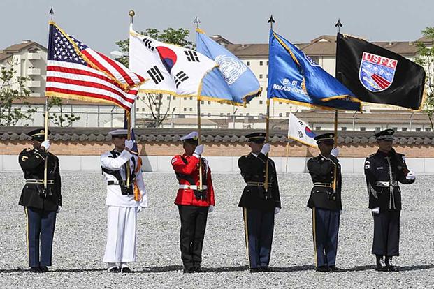 Troops display flags during a Memorial Day ceremony in South Korea