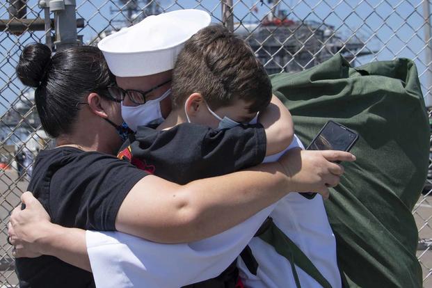 Electronics Technician 1st Class Vincent Testagrossa hugs his family following his return to Naval Base San Diego.