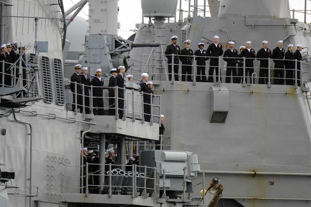 FILE PHOTO -- Sailors from the USS Leyte Gulf man the rails as the ship pulls in to port to conclude deployment.
