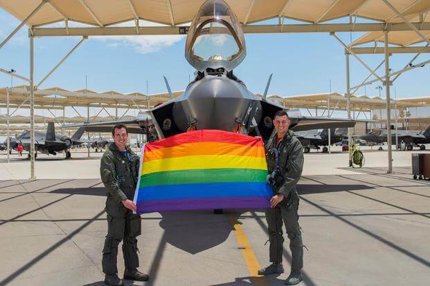 Maj. Tyler McBride and Justin Lennon hold an LGBTQ+ Pride flag at Luke Air Force Base.