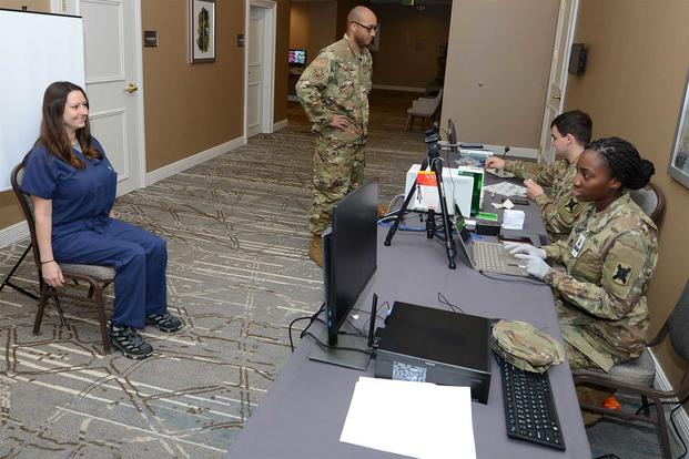 Soldiers create identification cards at a temporary medical facility in New Orleans.