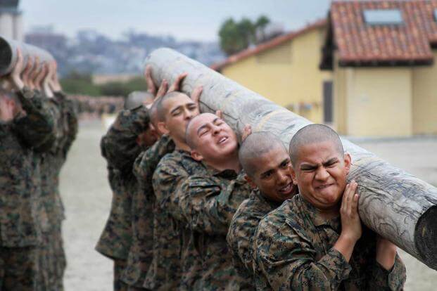 Recruits struggle to lift the front end of the log during log drills.