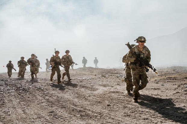 Infantrymen with the Army National Guard storm into action during an attack on the simulated village of Rajeesh, at the Army’s Fort Irwin National Training Center.