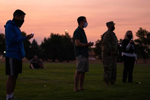 Airmen hold tea-light candles to honor those who have passed by suicide.