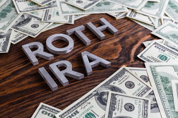 Words ROTH IRA sitting amid a pile of money