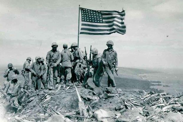 Marines raise U.S. flag atop Iwo Jima.