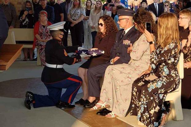 Aleta Bath accepts the flag at the funeral of Marine Pfc. Evan Bath. 
