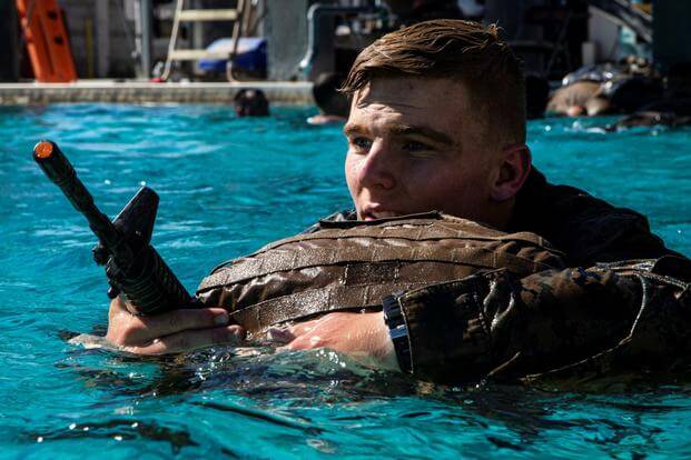 A Marine holds onto his pack while swimming 300 meters in a pool on Camp Pendleton.